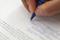 Photo of someone writing or signing a contract. Alternatively, just the photo of a contract.