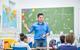 Photo of a teacher and their young students together in a classroom. Ideally, the teacher is speaking or writing something on the board.